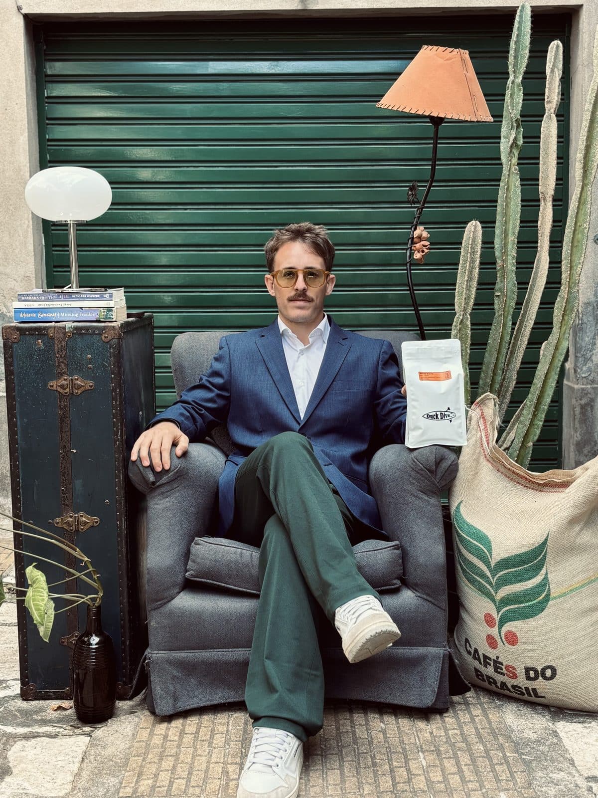Juan Cruz con una bolsa de Duck Dive, al lado de una arpillera de café verde de Brasil